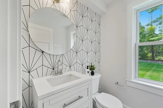a bathroom with a sink toilet and window