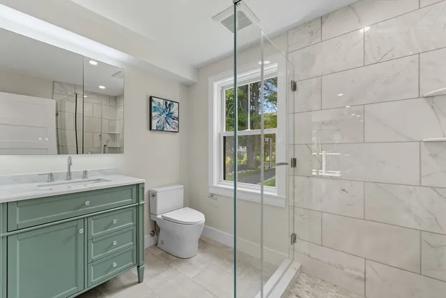 a bathroom with a granite countertop sink toilet and shower