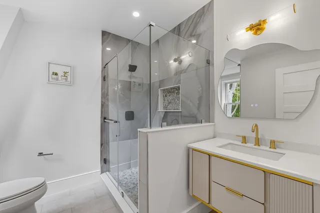 a bathroom with a sink a toilet and shower