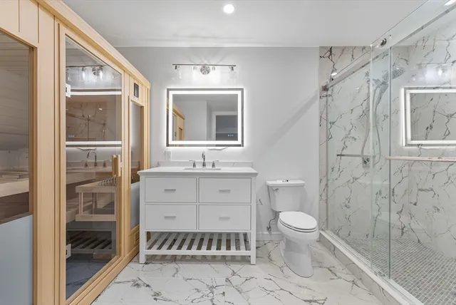 a bathroom with a granite countertop sink toilet and shower