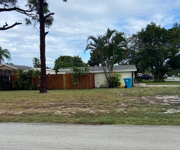a big house with a yard and large trees