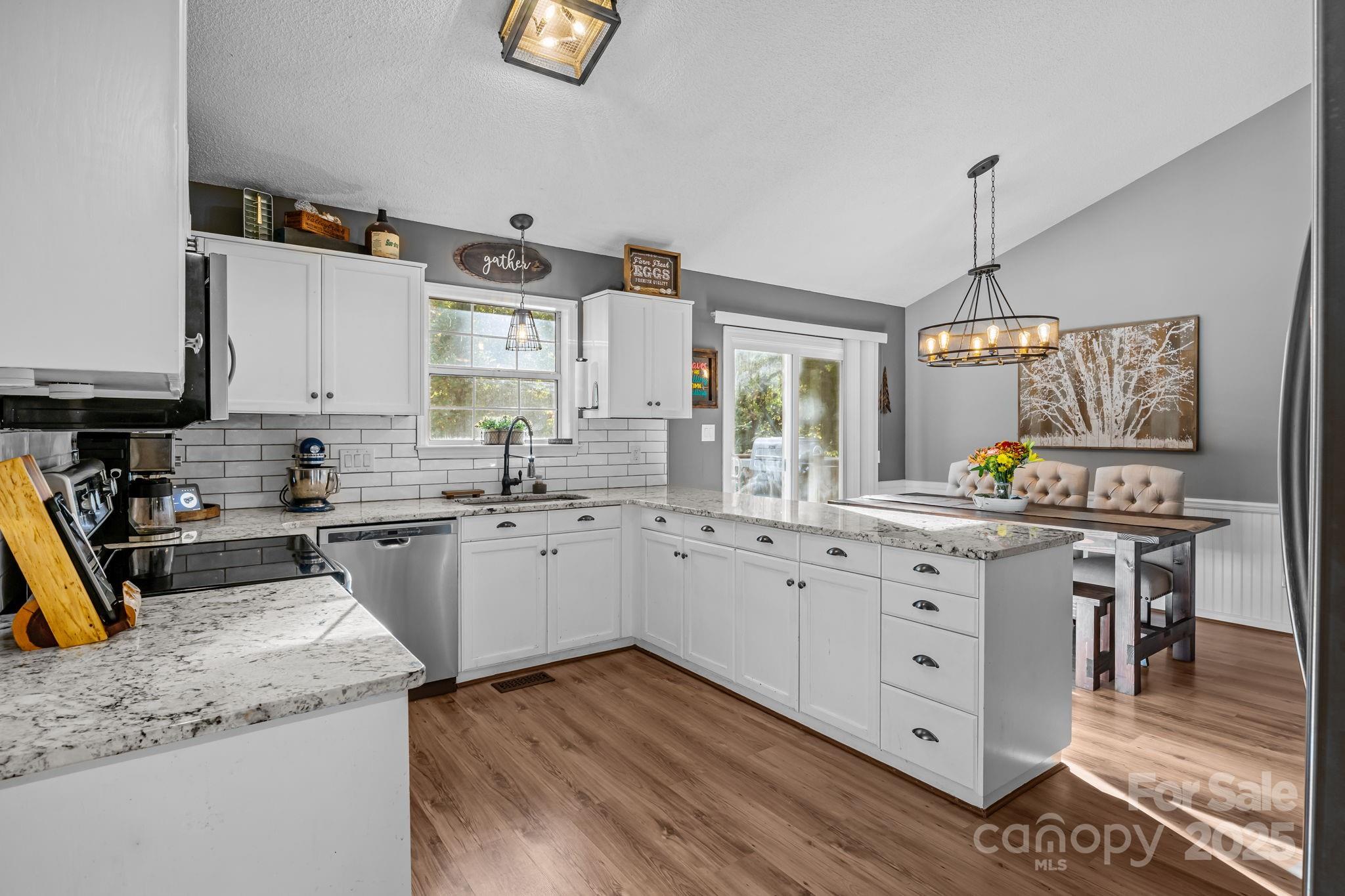 7229 Catawba Springs Road Denver, NC 28037 - Photo 19 of 48 a kitchen with granite countertop cabinets a sink a stove and wooden floor