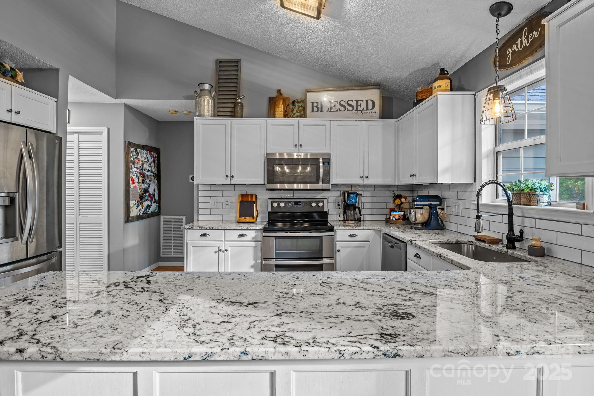 7229 Catawba Springs Road Denver, NC 28037 - Photo 23 of 48 a kitchen with stainless steel appliances granite countertop a stove a sink and a refrigerator