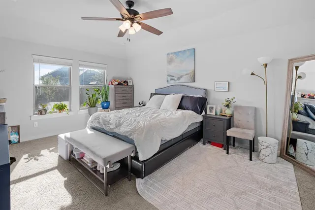 a bedroom with a large bed and a chandelier