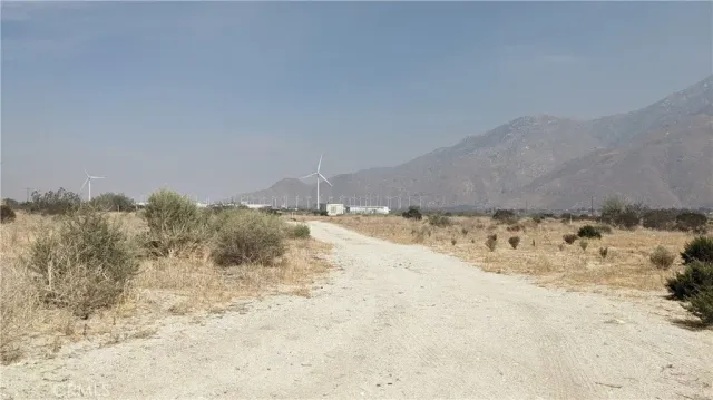 a view of a dry yard covered with snow in the background