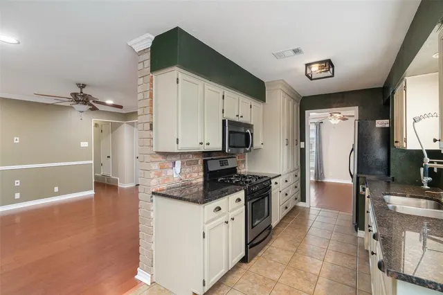 a kitchen with stainless steel appliances granite countertop a stove a sink and a refrigerator