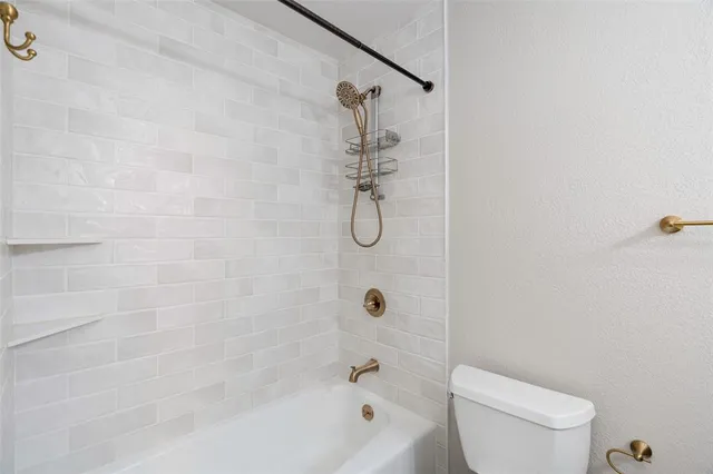 a bathroom with a shower a toilet and sink