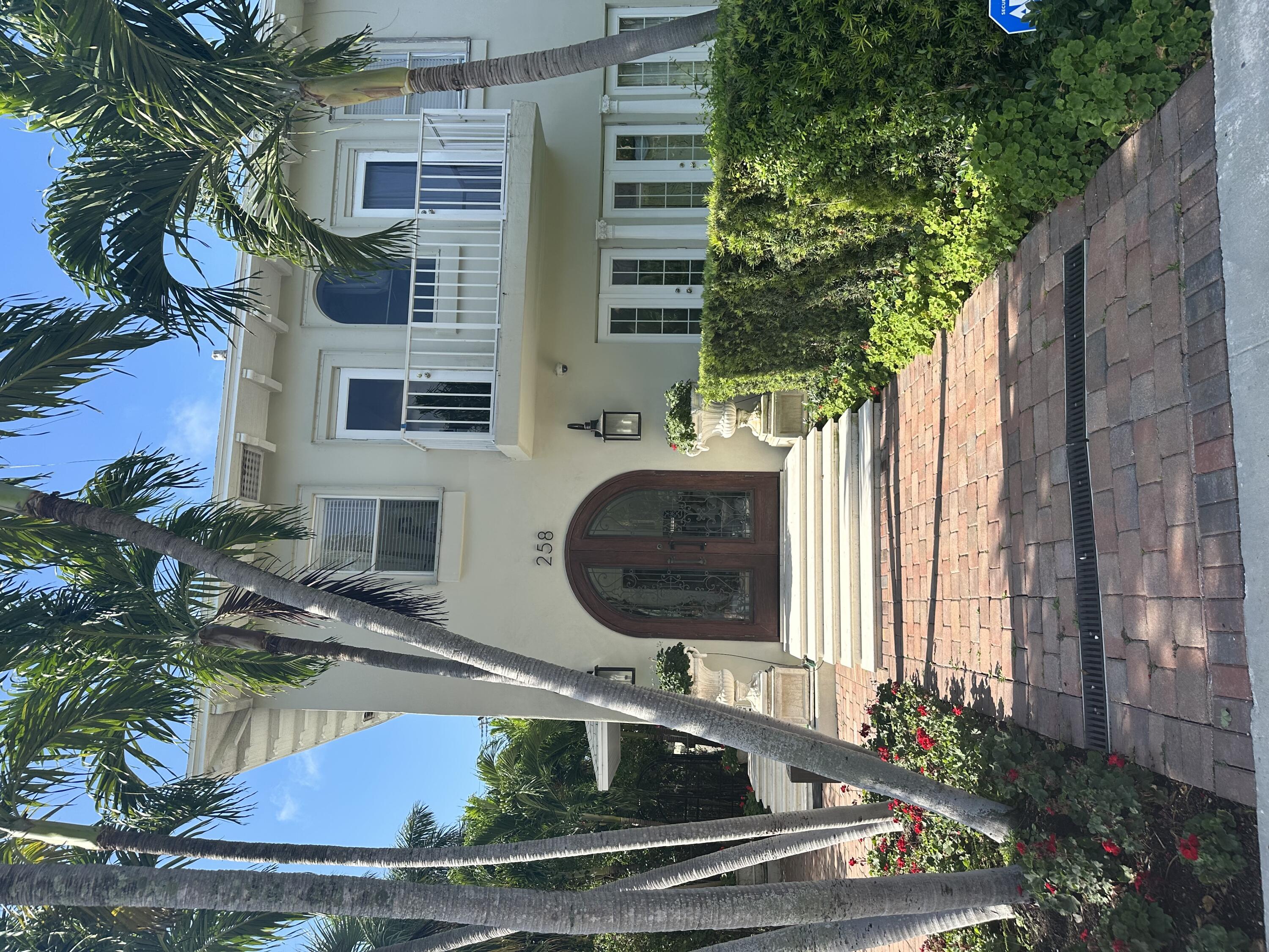 258 Seminole Avenue, Unit 4 Palm Beach, FL 33480 - Photo 1 of 10 a front view of a house with a garden