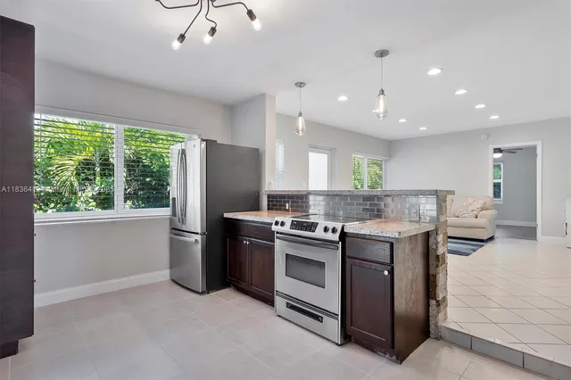 a kitchen with kitchen island a sink stove and refrigerator