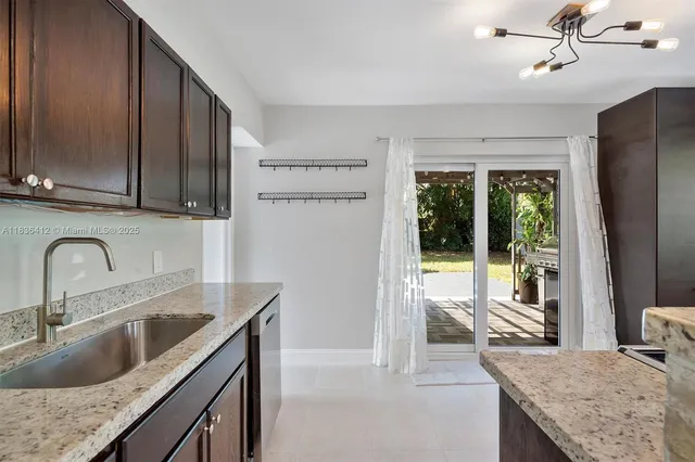 a kitchen with stainless steel appliances granite countertop a sink a stove and a refrigerator