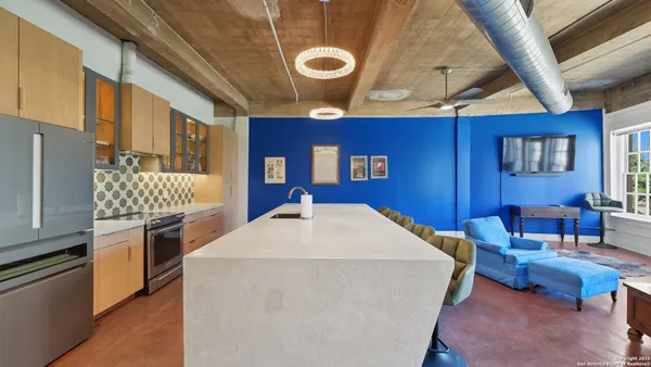 a kitchen with stainless steel appliances granite countertop a stove a refrigerator and a dining table