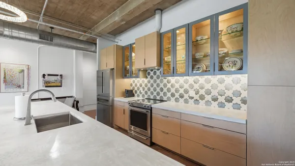 a kitchen with stainless steel appliances granite countertop a sink and a stove next to a window