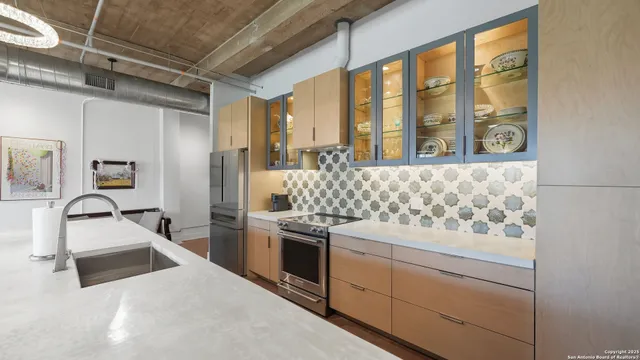 a kitchen with stainless steel appliances granite countertop a sink and a stove next to a window