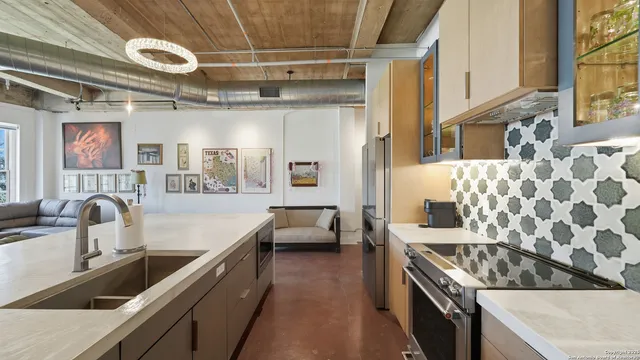 a kitchen with stainless steel appliances granite countertop a sink and a stove next to a window