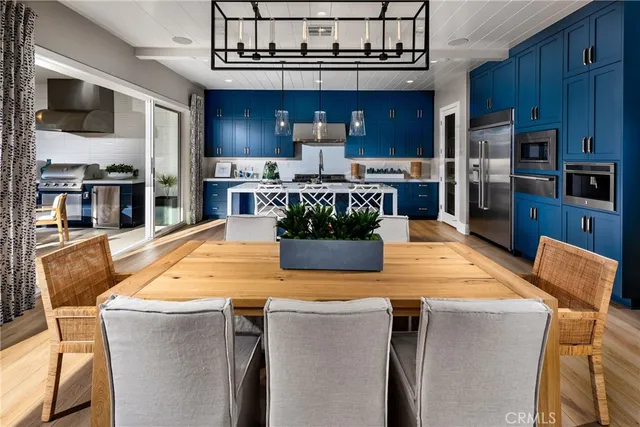 a kitchen with stainless steel appliances kitchen island granite countertop a table and chairs in it