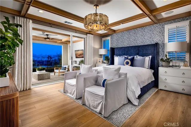 a spacious bedroom with a large bed and a chandelier