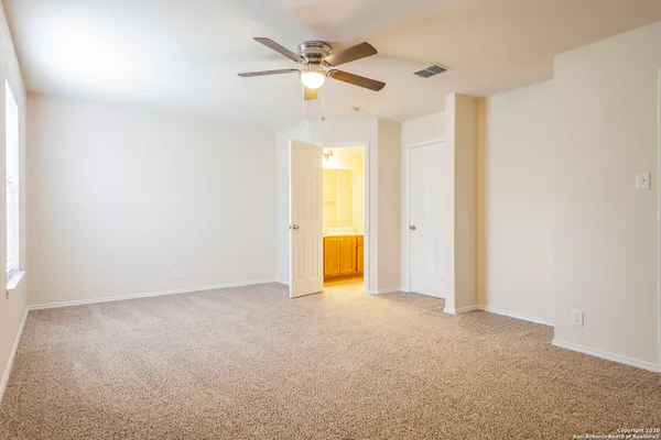an empty room with a ceiling fan and a window