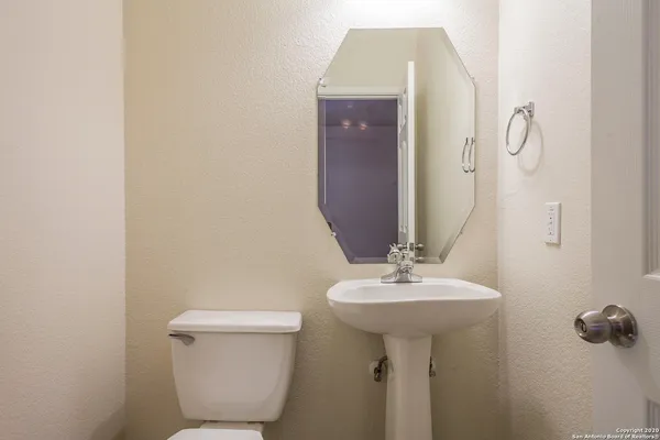 a bathroom with a sink toilet and a mirror