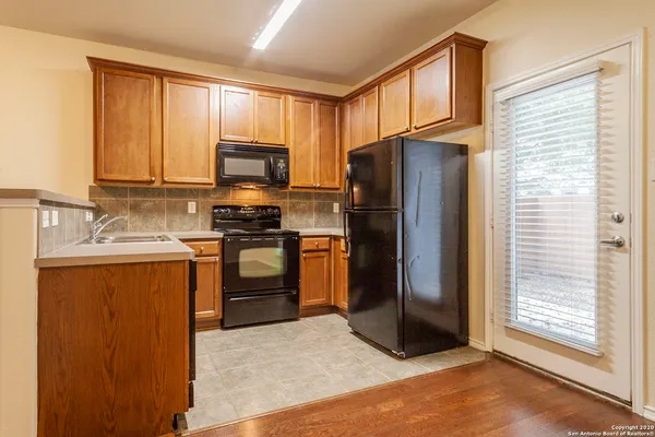 a kitchen with granite countertop a refrigerator stove top oven a sink and dishwasher