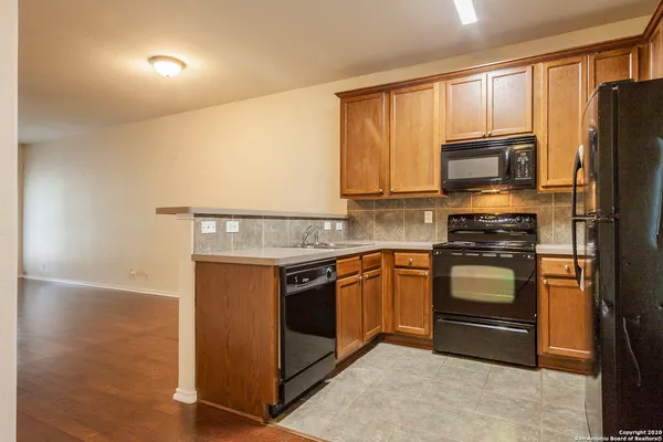 a kitchen with granite countertop a refrigerator stove and microwave