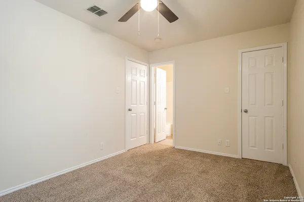 an empty room with chandelier fan