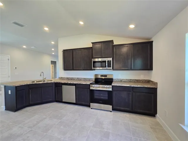 a kitchen with stainless steel appliances granite countertop a sink a stove and a granite counter tops