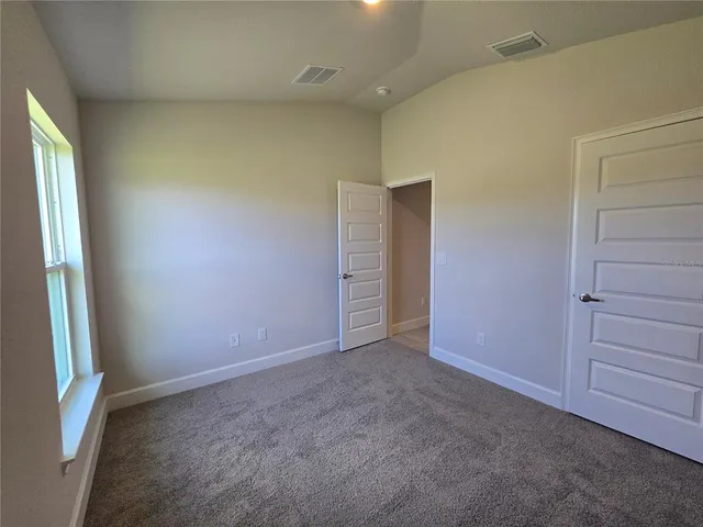 an empty room with closet and a window