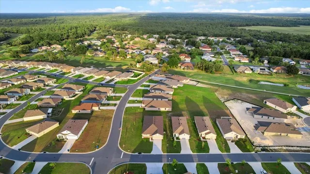 an aerial view of residential houses with outdoor space and parking
