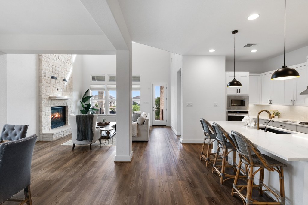 305 Avena Trail Austin, TX 78738 - Photo 20 of 40 Spacious open-concept living area with lvp flooring, soaring ceilings, and seamless flow into the kitchen, complete with a large island and stylish pendant lighting.