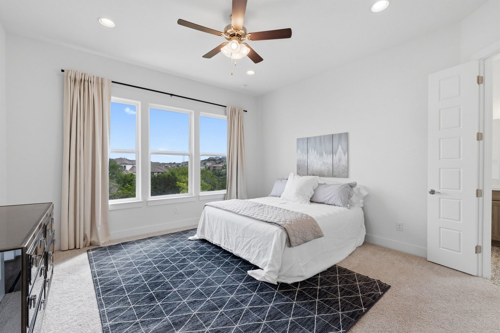 305 Avena Trail Austin, TX 78738 - Photo 7 of 40 a spacious bedroom with a large bed and a window