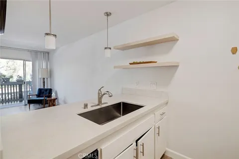 a kitchen with a sink a counter and chairs
