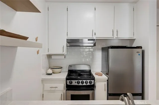 a kitchen with stainless steel appliances white cabinets and a granite counter tops