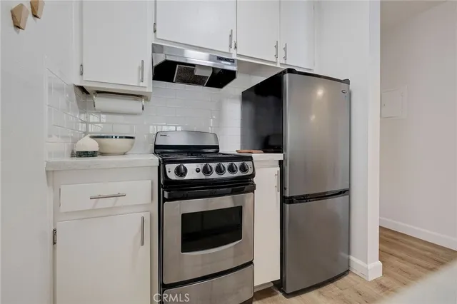 a kitchen with a sink a stove and cabinets