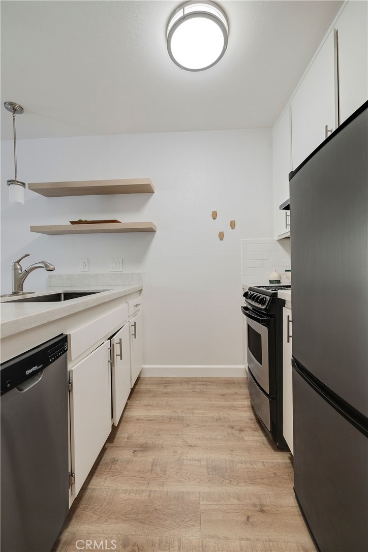 3604 West Estates Lane, Unit 114 Rolling Hills Estates, CA 90274 - Photo 21 of 59 a kitchen with granite countertop a stove and a refrigerator