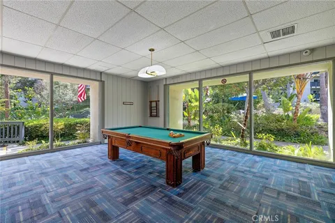 a view of house with swimming pool and trees in the background