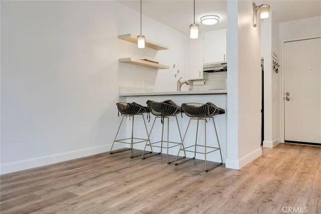 an empty room with wooden floor and ceiling fan