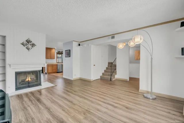 a view of empty room with wooden floor and fireplace