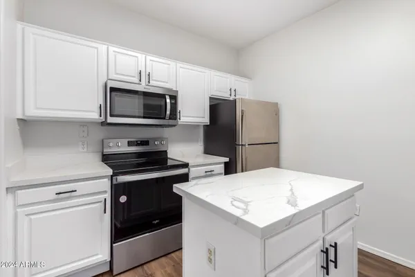 a kitchen with stainless steel appliances a stove microwave and refrigerator