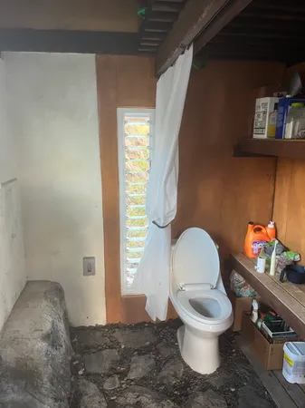 a bathroom with a toilet a sink and a window