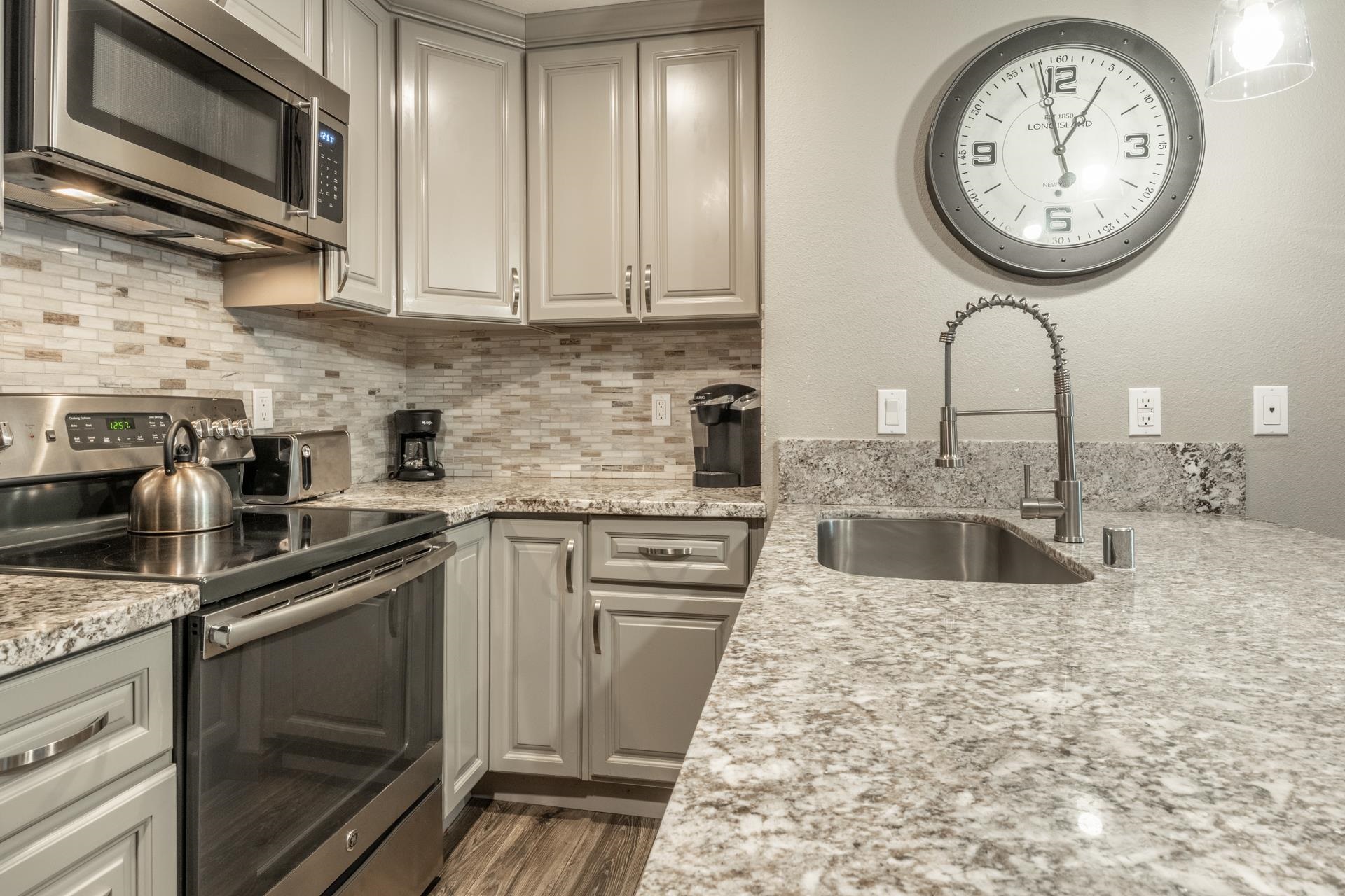 2499 Sierra Nevada Road, Unit S1 Mammoth Lakes, CA 93546 - Photo 12 of 38 Kitchen with stainless steel appliances, light stone countertops, decorative backsplash, and dark wood-style flooring