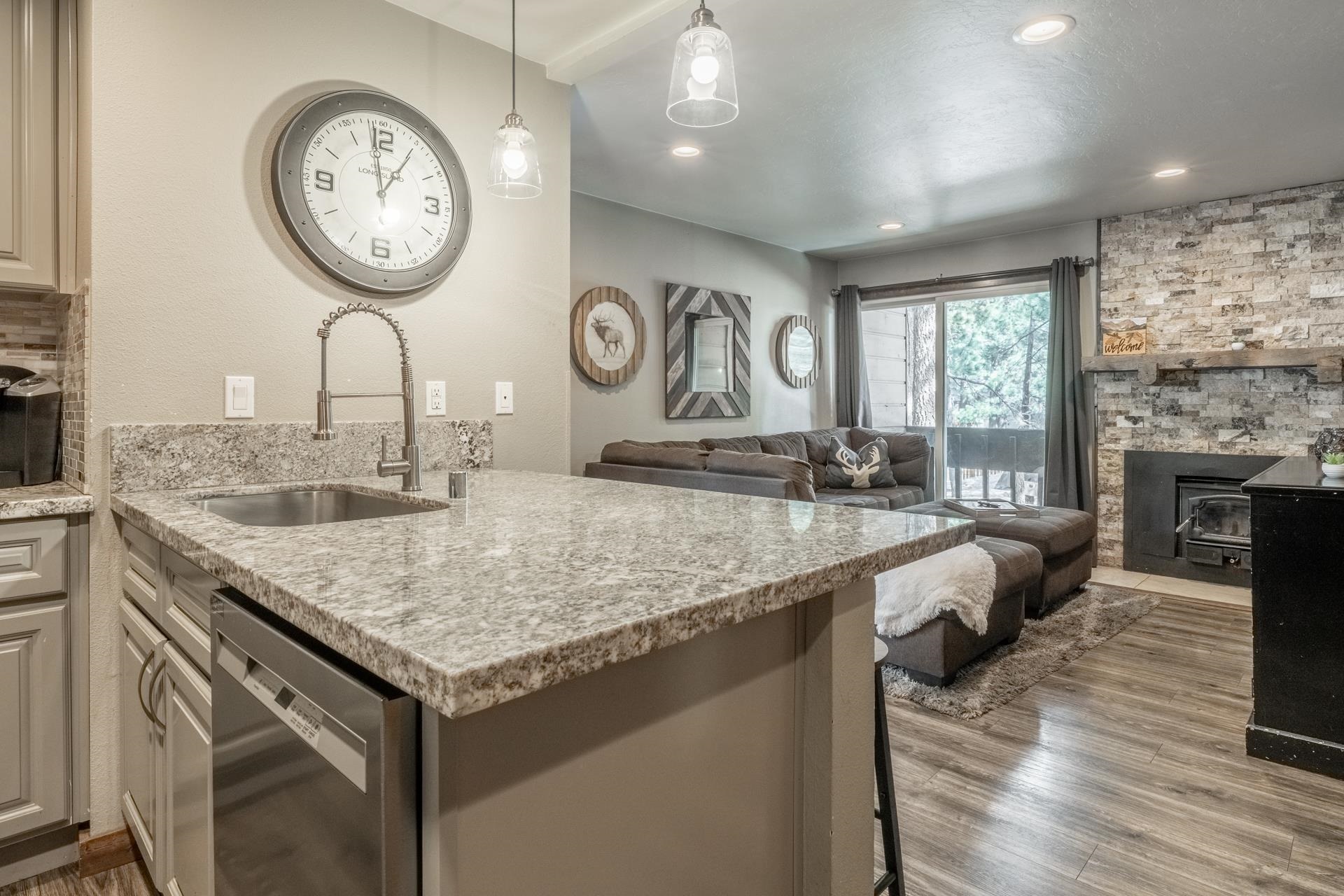 2499 Sierra Nevada Road, Unit S1 Mammoth Lakes, CA 93546 - Photo 37 of 38 Kitchen with light stone counters, stainless steel dishwasher, a peninsula, open floor plan, and hanging light fixtures