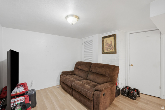 707 East 150 South Provo, UT 84606 - Photo 21 of 31 Finished room featuring wood-finish flooring, white painted walls, a flush-mount ceiling light, and a white interior door with a brass-finish knob