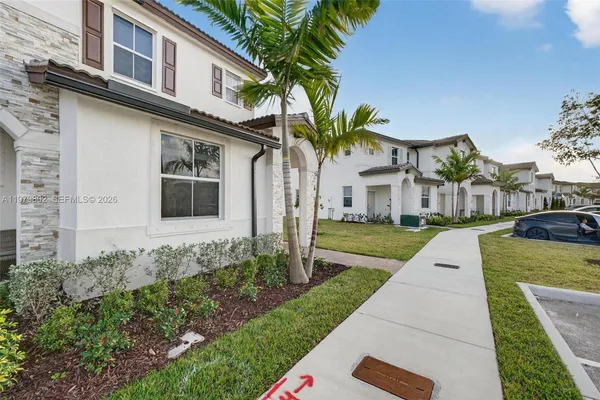 a front view of a house with a yard and potted plants