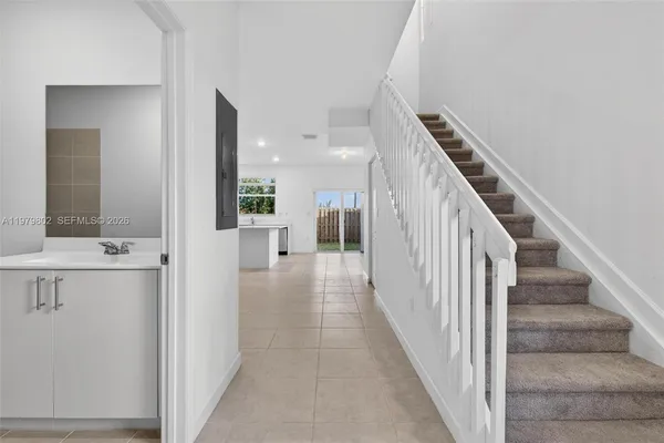 a view of a hallway with white walls and stair