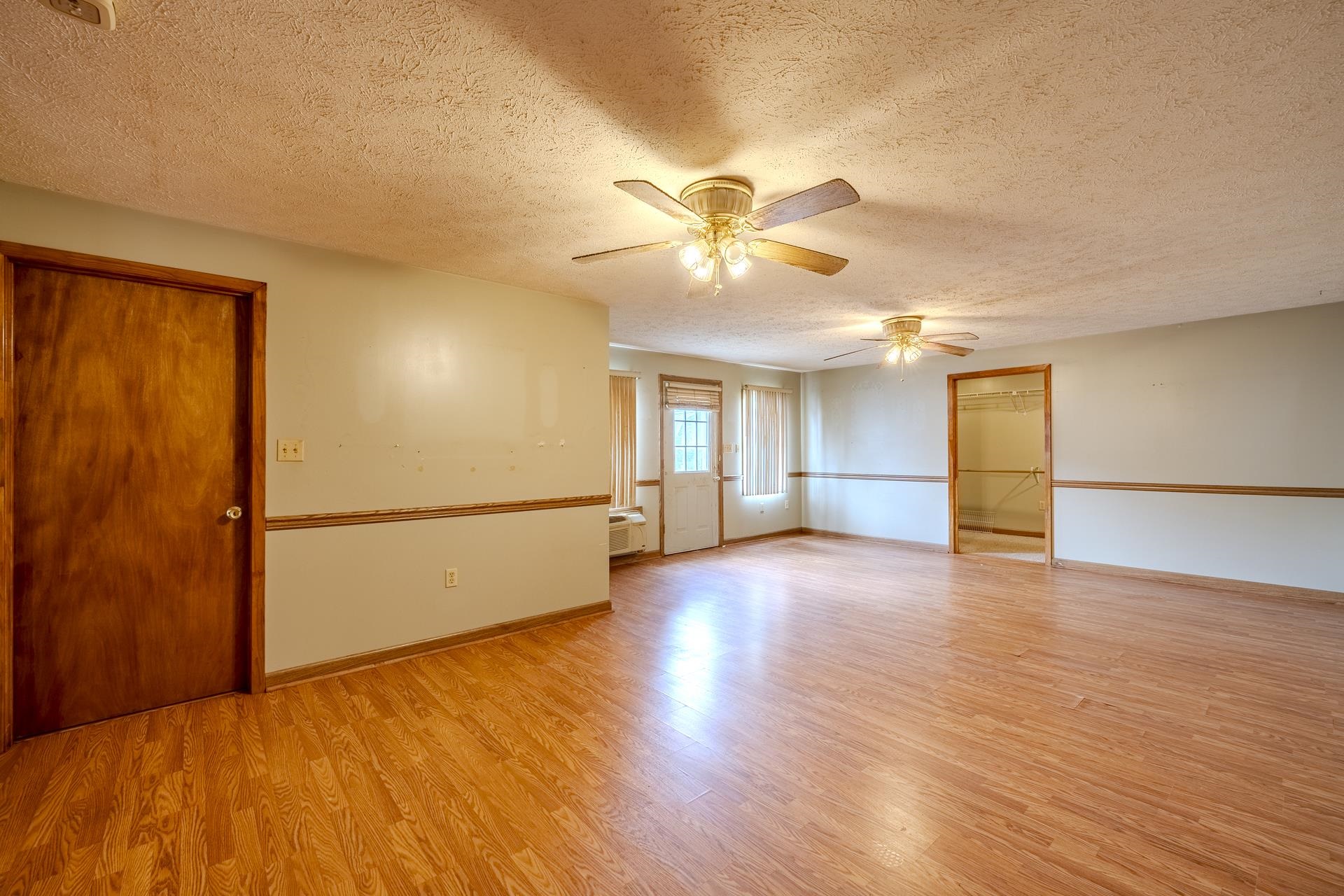 859 Old Morris Chapel Road Adamsville, TN 38310 - Photo 28 of 39 Spacious interior with wood-finish flooring, two ceiling fans with integrated lighting, and a door with glass paned inserts
