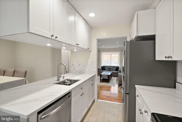 a large white kitchen with a sink and dishwasher