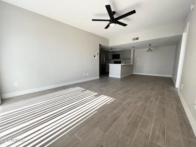 an empty room with a windows and ceiling fan