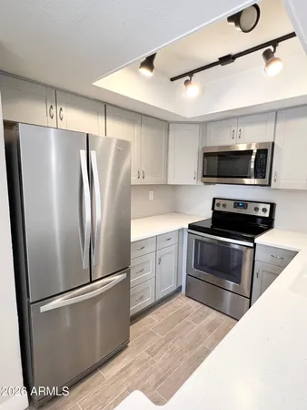 a kitchen with stainless steel appliances a refrigerator sink and microwave