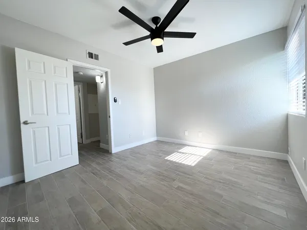 an empty room with wooden floor and windows