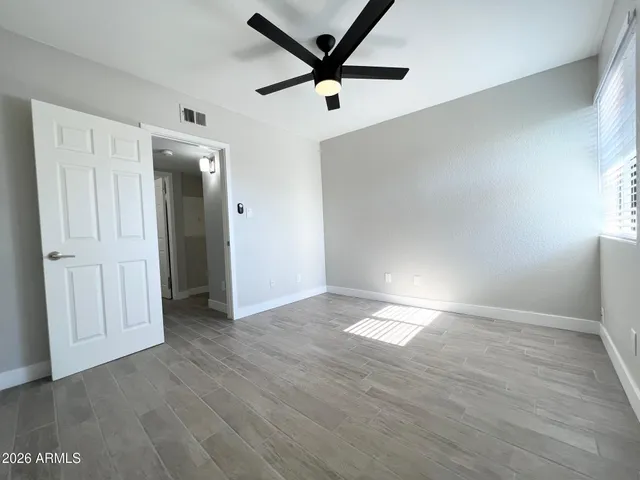 an empty room with wooden floor and windows
